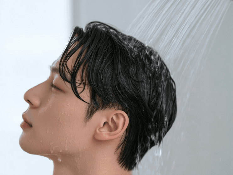샤워기로 두피를 깨끗하게 헹구는 장면